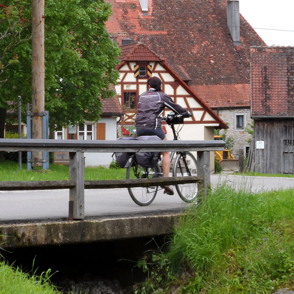Fahrradfahrer vor einem fränkischen Fachwerkhaus